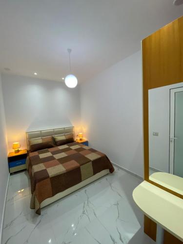 a bedroom with a bed and two lamps on two tables at Pogradeci Apartments in Pogradec