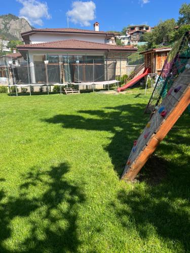 a playground with a slide in a yard at SPA Hotel Daffi in Smolyan