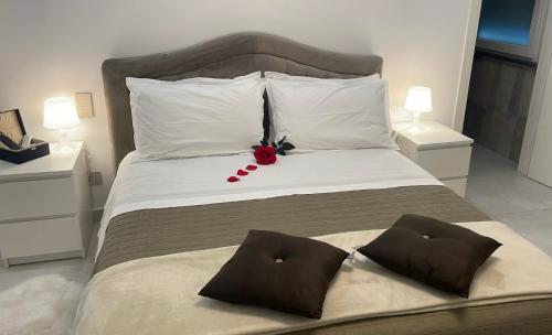 un letto con un fiore rosso sopra di Varese Apartment a Varese