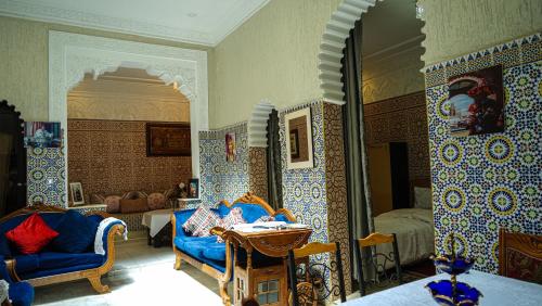 Exquisite Riad Beach & Surf في الرباط: غرفة معيشة مع جدران من البلاط الأزرق والأبيض
