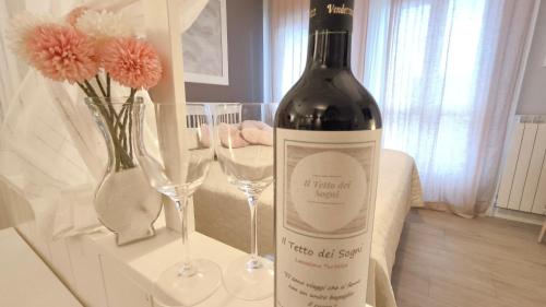 eine Flasche Wein neben zwei Weingläsern in der Unterkunft Il Tetto dei Sogni in Pistoia