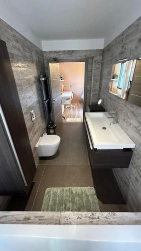 une salle de bain avec un lavabo, des toilettes et une baignoire dans l'établissement Villa contemporaine avec lagon, à Sanary-sur-Mer