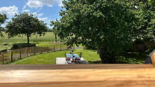 a view of a yard with a table and a tree at Ty Oliv- entre terre et ocean in Plonéour-Lanvern