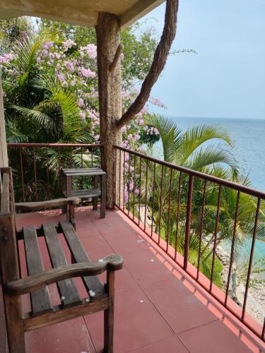 a bench sitting on a balcony overlooking the water at Hotel Restaurante La Villa de los Dioses in San Antonio Palopó