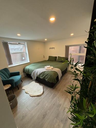 een slaapkamer met een groen bed en een blauwe stoel bij Williamson Suites - Apartment 1 in Liverpool
