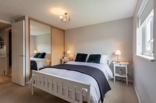 sypialnia z dużym białym łóżkiem i lustrem w obiekcie Modern 2 Bed Apartment Near Gatwick w mieście Crawley