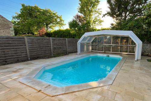 une piscine avec une serre dans une cour arrière dans l'établissement Les Gîtes du Chaix, à Dissay