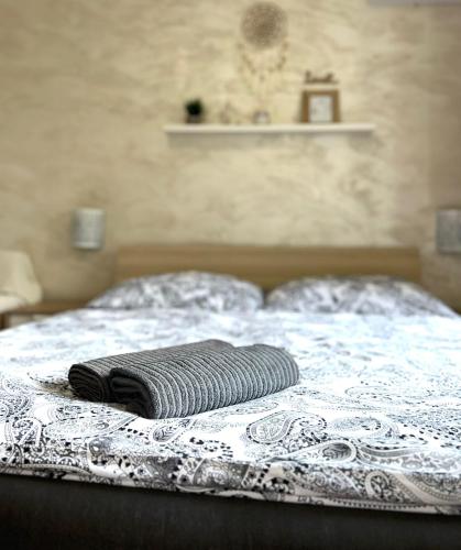a black and white blanket on top of a bed at Apartmány ZELENÝ DOM in Podhájska