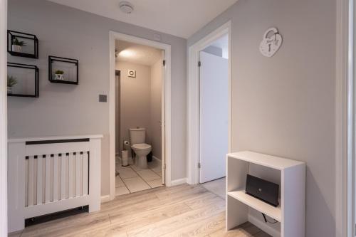 a bathroom with a toilet and a television in a room at Modern 2 Bed Apartment Near Gatwick in Crawley