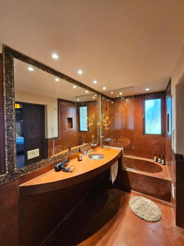 ein großes Bad mit einem Waschbecken und einem großen Spiegel in der Unterkunft La Sala in Lozano