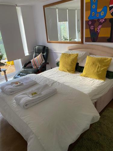 a large white bed with towels on top of it at Pond Cottage in Purley