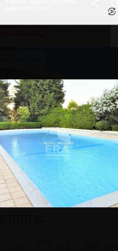 une photo d'une piscine bleue dans l'établissement Spacieux 2 pièces terrasse et piscine, à Cannes