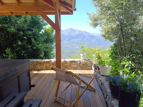 a chair on a deck with a view of a mountain at Parfumu Di Celu in Corte