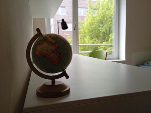 ein Globus auf einem Tisch neben einem Fenster in der Unterkunft Studio Suite near University in Bremen