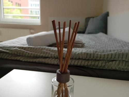 a vase sitting on a table with sticks in it at Studio Suite near University in Bremen