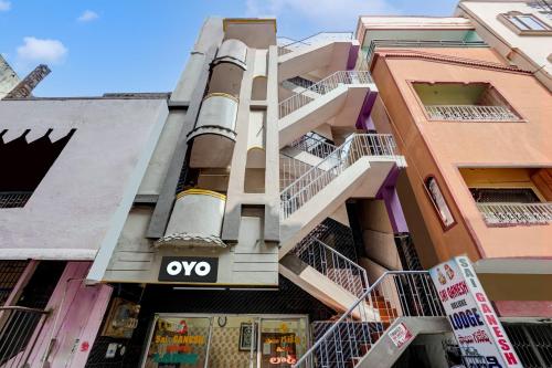 un edificio de apartamentos con un cartel ovy en OYO Flagship Sai Ganesh Deluxe Lodge en Tirupati