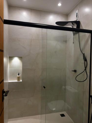 a shower with a glass door in a bathroom at Hospedaria Capulus in Divisa