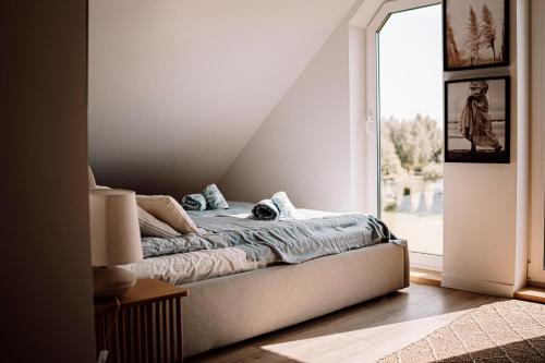 a bed sitting in a room with a window at Prawdziwe Morze in Sasino
