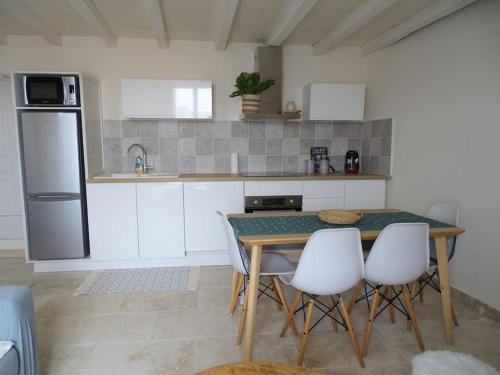 une cuisine avec une table et des appareils électroménagers blancs dans l'établissement Maison avec terrasse panoramique, à Châteauneuf-de-Gadagne
