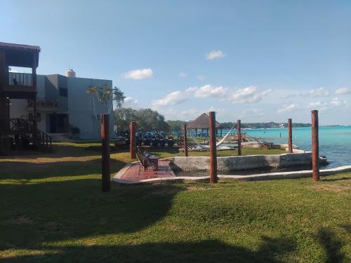 a park bench sitting next to a body of water at Blue Caribe Bacalar Front Lagoon in Bacalar