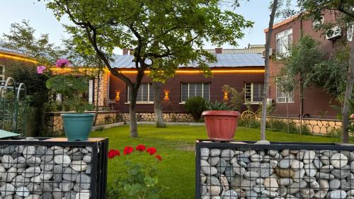 a house with a retaining wall and some flowers at Afghania Guest House in Kabul