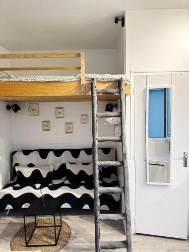Ce lit superposé se trouve dans un dortoir avec une échelle. dans l'établissement Studio Centre de Paris - Marais, à Paris