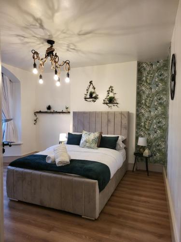 a bedroom with a large bed and a chandelier at Country Style Modern Self Catering 3 Bedroom Bungalow in Blackpool in Blackpool