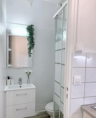 une salle de bain blanche avec un lavabo et des toilettes dans l'établissement Studio Centre de Paris - Marais, à Paris
