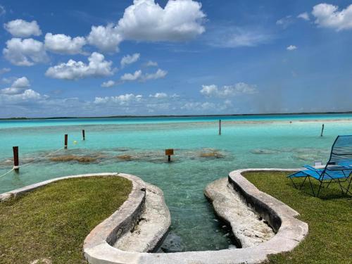a blue chair sitting in the water near the ocean at Blue Caribe Bacalar Front Lagoon in Bacalar