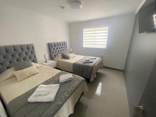 een slaapkamer met 2 bedden en een raam bij Apart Fueguina in Porvenir