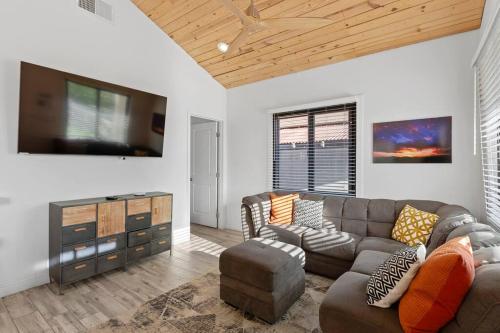 a living room with a couch and a flat screen tv at Hummingbird Harmony House with BBQ and Hot Tub in Downtown Phoenix in Phoenix