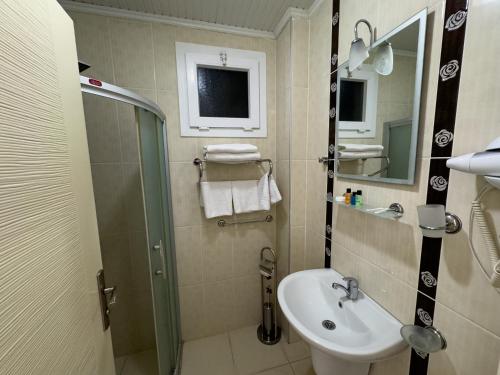 a small bathroom with a sink and a shower at Sardunya Hotel in Fethiye