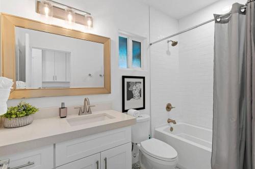 a bathroom with a sink and a toilet and a mirror at Hummingbird Harmony House with BBQ and Hot Tub in Downtown Phoenix in Phoenix