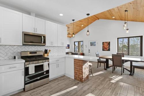 a kitchen with white cabinets and a dining room at Hummingbird Harmony House with BBQ and Hot Tub in Downtown Phoenix in Phoenix