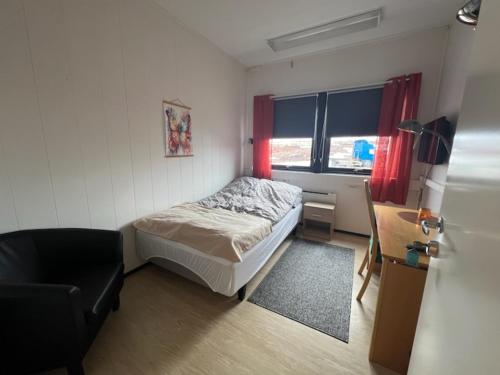 a small bedroom with a bed and a chair at Odd inge Sør-Reime as in Nesseby