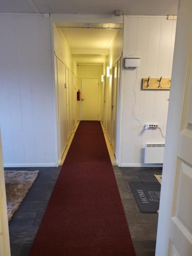 a long corridor with a red carpet in a hallway at Odd inge Sør-Reime as in Nesseby