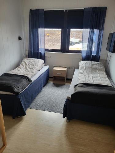 a small room with two beds and a window at Odd inge Sør-Reime as in Nesseby