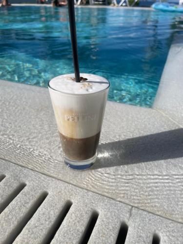 un drink seduto su un tavolo accanto alla piscina di Pine Resort a Polykhrono