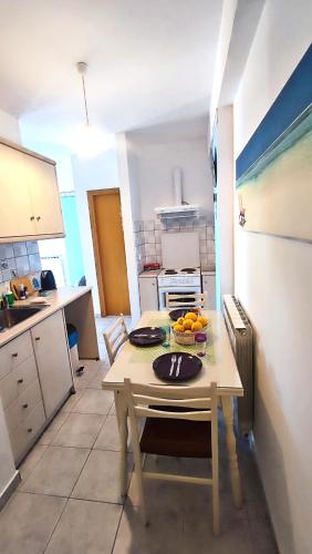 a kitchen with a table with a bowl of fruit on it at Aeolos Studios Kefalonia in Khelmáta