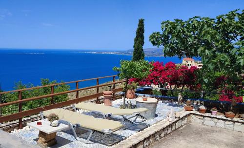 a patio with two tables and a view of the ocean at Aeolos Studios Kefalonia in Khelmáta