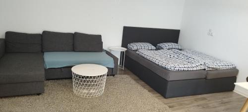 a living room with a couch and a table at Schönes und offenes Appartement in Jüchen