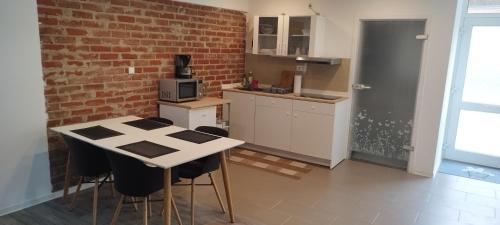 uma cozinha com uma mesa e cadeiras e uma parede de tijolos em Schönes und offenes Appartement em Jüchen