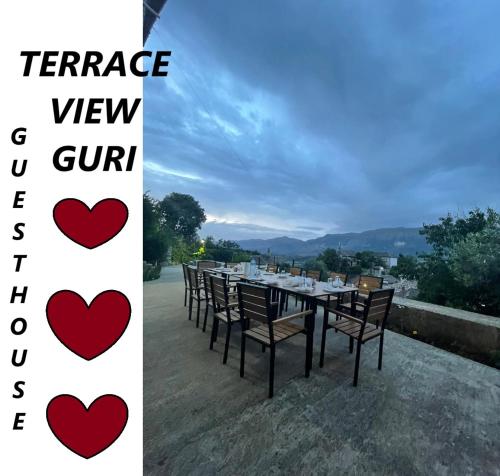 a table with chairs and a sign that reads terrace view g chill at Guri Guesthouse in Gjirokastër