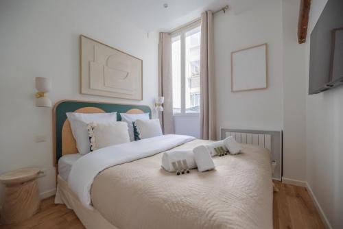 une chambre avec un lit avec deux serviettes dessus dans l'établissement CIA - Amazing loft bastille, à Paris