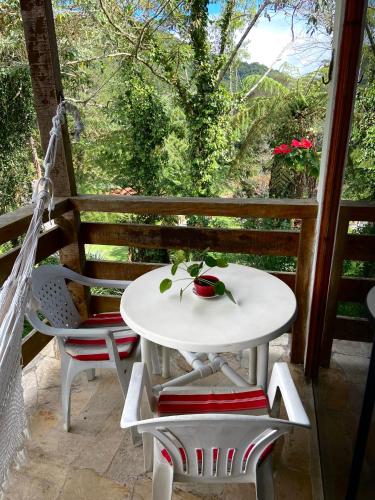 a white table and chairs on a porch at Chalé aconchegante em Mury in Nova Friburgo