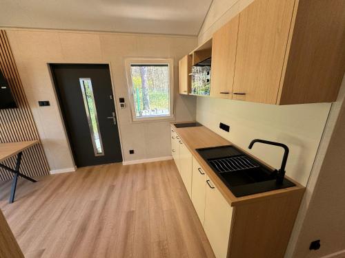 a small kitchen with wooden cabinets and a sink at Apartamenty i Domki WyDmy Międzywodzie in Międzywodzie