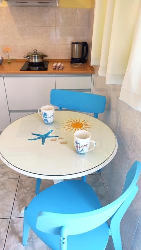 a table with two chairs and two cups on it at Aeolos Studios Kefalonia in Khelmáta