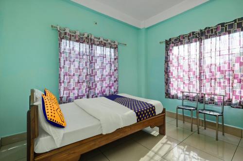 KāhārpāraにあるSPOT ON Sunrise Lodge & Axomiya Dhabaのベッドルーム1室(青い壁と窓のあるベッド1台付)