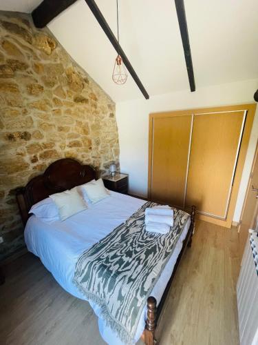 a bedroom with a bed and a stone wall at Casa rural Safurdão in Safurdão