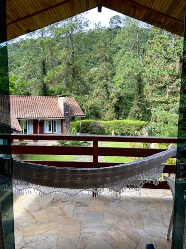 a view from the balcony of a house with a hammock at Chalé aconchegante em Mury in Nova Friburgo